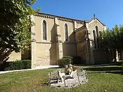 Vue latérale, avec au premier plan une statue fleurie.