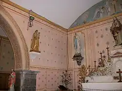 Sur la gauche, une statue sculptée en bois et dorée de la Vierge à l'Enfant datant du XVIIIe&nbsp;siècle.