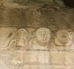 Détails (trois masques ?) du portail roman (XIIe&nbsp;siècle) de l'église.
