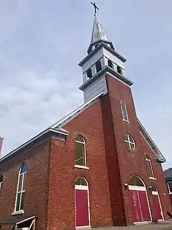 Façade vue de côté de l’Église Saint-Laurent, en briques rouges.