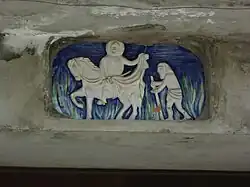 Émail ornant la façade de l’église, représentant la célèbre scène du partage du manteau.