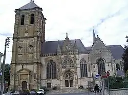Photo d'une église de style gothique avec un clocher imposant ressemblant à une tour.