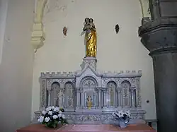 Le tabernacle est surmonté d'une statue de la Vierge à l'Enfant