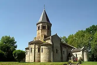 Église de Biozat. On distingue à droite la chapelle funéraire de la famille Hutteau d'Origny et, devant celle-ci, la borne milliaire romaine ainsi qu'un bloc, dit « pierre celtique ».