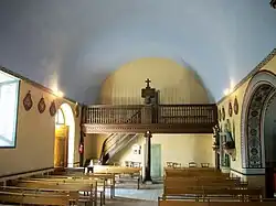 Partie arrière de la nef. Avec la tribune, l'escalier et l'accès au clocher.