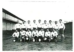 Photographie en noir et blanc représentant seize personnes.