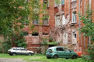 Les briques de la façade tombent ; des fenêtres sont murées.