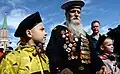 Georgy Shirokov, 91 ans, vétéran de la Seconde Guerre mondiale, et ancien marin de la flotte de la Baltique, marche avec ses arrière-petits-enfants