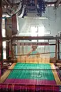 Une femme sur un métier à tisser. Dans une fabrique traditionnelle à Dharmavaram.