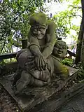 Sculpture d'un démon donnant une fessée à un défunt
