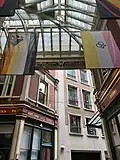 Drapeau bear : une patte d'ours stylisée en haut à gauche de 7 bandes de différentes teintes de marron, orange, jaune et blanches. Drapeau twink : 3 bandes horizontales (rose, blanc et jaune) avec 2 symboles de la masculinité (♂) entrelacés.