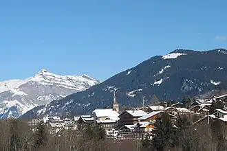 Photographie numérique couleur. Village au toits eneigés dans une montagne. Arrière-plans montagnes eneigées.