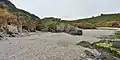 Falaises et grottes de l'anse de Ty Mark vues depuis sa grève à marée basse.