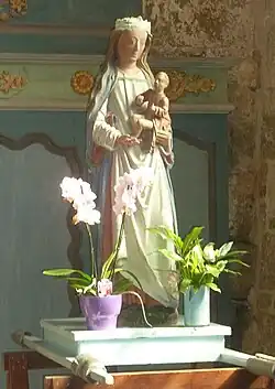 Statue  de bois peint : femme en longue robe blanche revêtue d'une cape bleue, tenant un enfant assis sur son bras.
