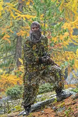 Personne en tenue de camouflage kaki.