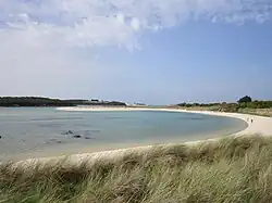 La plage du Guillec (rive droite de l'estuaire du Guillec), à l'arrière-plan le port de Moguériec