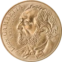 Pièce de monnaie métallique à l'effigie d'un homme barbu, vu de profil.