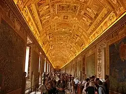 Photo d'une galerie au plafond richement peint et aux murs couverts de cartes.