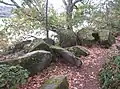 Blocs de kersantite (résidus de carrière) abandonnés le long du sentier piétonnier longeant la rive nord de la ria du Camfrout près de Kersanton.