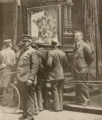Visiteurs s'arrêtant devant la carte à l'Exposition universelle. Reproduction d'une photographie parue en une de La Vie illustrée en date du 18 mai 1900.