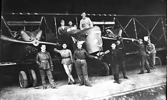 Groupe et F.50 à l'entrée d'un hangar.