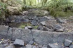 Plus au Sud : Des grès pourpres en gradins affleurent dans le lit du ruisseau de la Roche.