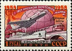 timbre à tons rose et orange, représentant un Tu-104 aux côtés d'un train et d'un navire cargo.