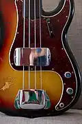 Détail d'une Precision Bass de 1972, avec le repose doigts en bas des cordes et le capot en métal au-dessus du micro pour y poser la main et jouer avec le pouce.