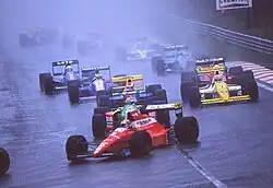 Photo de nombreuses voitures de Formule 1 sur une piste détrempée