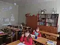 Début d'année, des élèves s'apprêtent à écrire sur la dictée, retenant leur stylo.