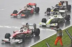 Photo des voitures de Barrichello, Trulli, Hamilton et Webber arrêtées sur une piste détrempée