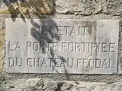 Photographie en couleurs d'une plaque apposée sur un bâtiment et gravée d'une inscription.
