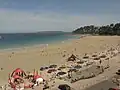 La plage de Trestraou en saison touristique ; au large l'île Tomé).