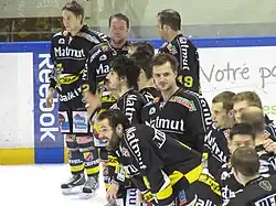 Photographie des joueurs de hockey sur glace de Rouen avec leurs maillots noirs