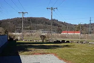 Des pylônes et des bâtiments avec une colline à l'arrière plan.