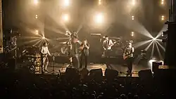 Un groupe de cinq musiciens sur une scène.