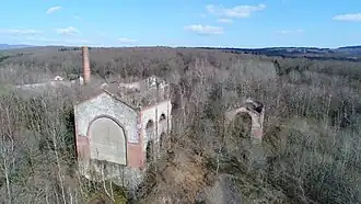 Groupe de bâtiments surmontés d'une cheminée en brique rouge.