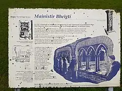 Photographie couleur d'un panneau explicatif illustré racontant brièvement l'histoire de l'abbaye en anglais et en irlandais.