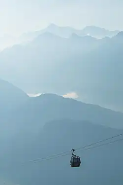 Une cabine toute petite dans le vertige d'une brume bleutée, simplement soutenue par quelques câbles.