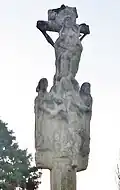 Le calvaire du placître de l'église Saint-Théleau, partie sommitale, face représentant trois femmes dont la Vierge Marie soutenant le corps de Jésus.