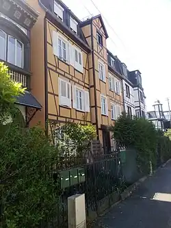 Petit immeuble de 4 étages à la façade jaune paille (colombages)