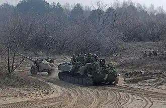 La 59e&nbsp;brigade motorisée s’entraînant en 2017 avec un canon MT-12 Rapira tracté par un MT-LB.