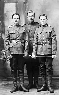 Portrait en noir et blanc de trois jeunes hommes en uniformes militaires