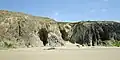 Les falaises et les grottes au nord de la plage de Ty Anquer vues de la plage à marée basse.