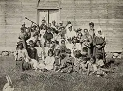 Photo en noir et blanc de plus de vingt personnes en habits quotidiens devant un bâtiment typiquement rapanui.