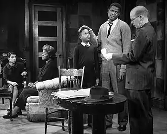 Une scène de la mise en scène de 1959. De gauche à droite : Ruby Dee (Ruth), Claudia McNeil (Lena), Glynn Turman (Travis), Sidney Poitier (Walter), John Fiedler (Karl Lindner).