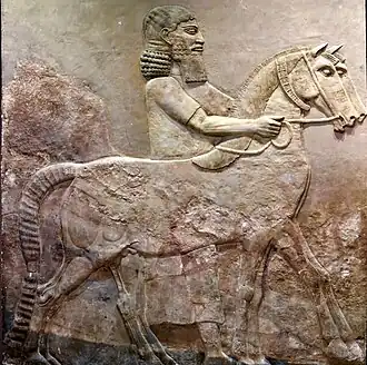 Bas-relief d'un palefrenier assyrien et de ses chevaux, palais royal de Dur-Sharrukin, vers 710 av. J.-C., conservé au musée national d'Irak.