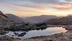 Un petit lac qui pourrait presque être une flaque d'eau. Une gelée blanche tapisse la lande ocre. Des collines laissent ouverte la perspective vers de petites montagnes. Le ciel bleu hésite entre le jour et la nuit.