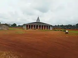 Photographie d'un monastère bas devant lequel est construite une église octogonale.