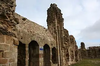 Le mur sud du cloître, vu de l'emplacement du réfectoire.